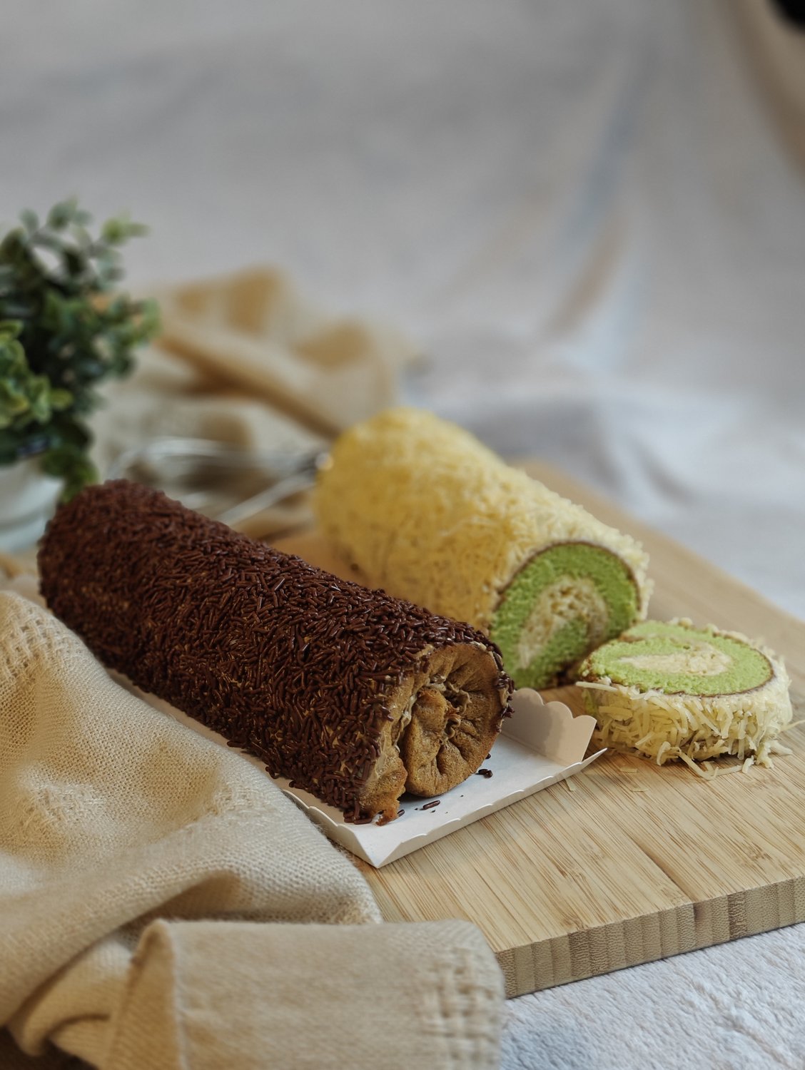 Indonesian roll cakes in chocolate and pandan cheese showing swirling interior